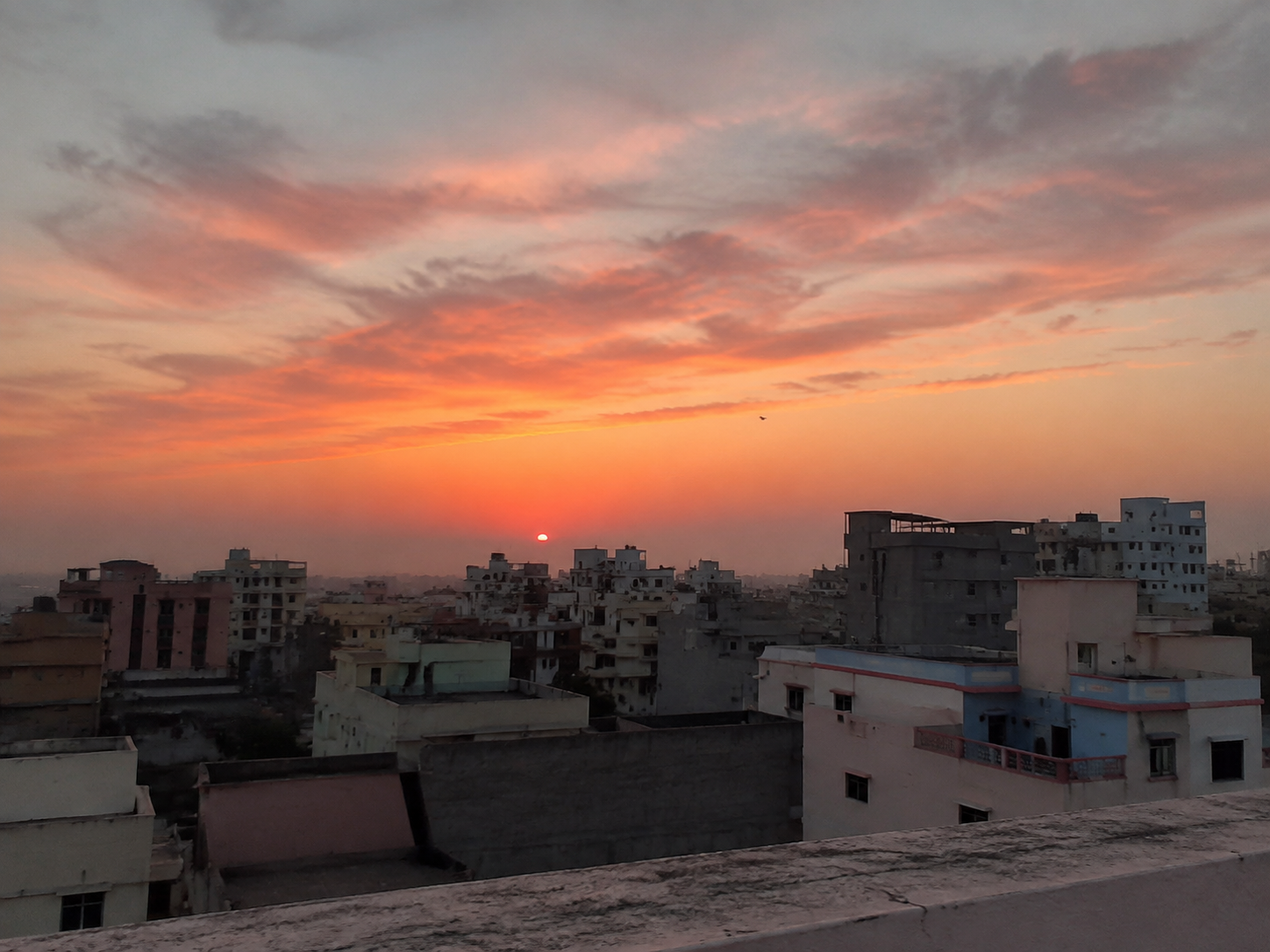 Orange and pink sunset above a city skyline